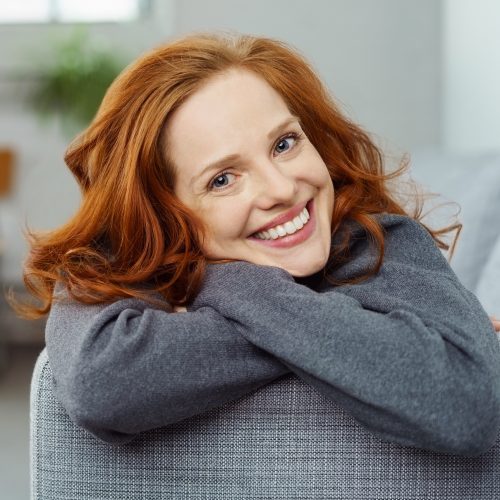 lächelnde frau liegt auf dem sofa lächelnde frau liegt auf dem sofa