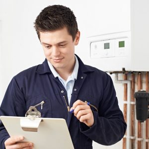 Male Plumber Working On Central Heating Boiler Male Plumber Working On Central Heating Boiler